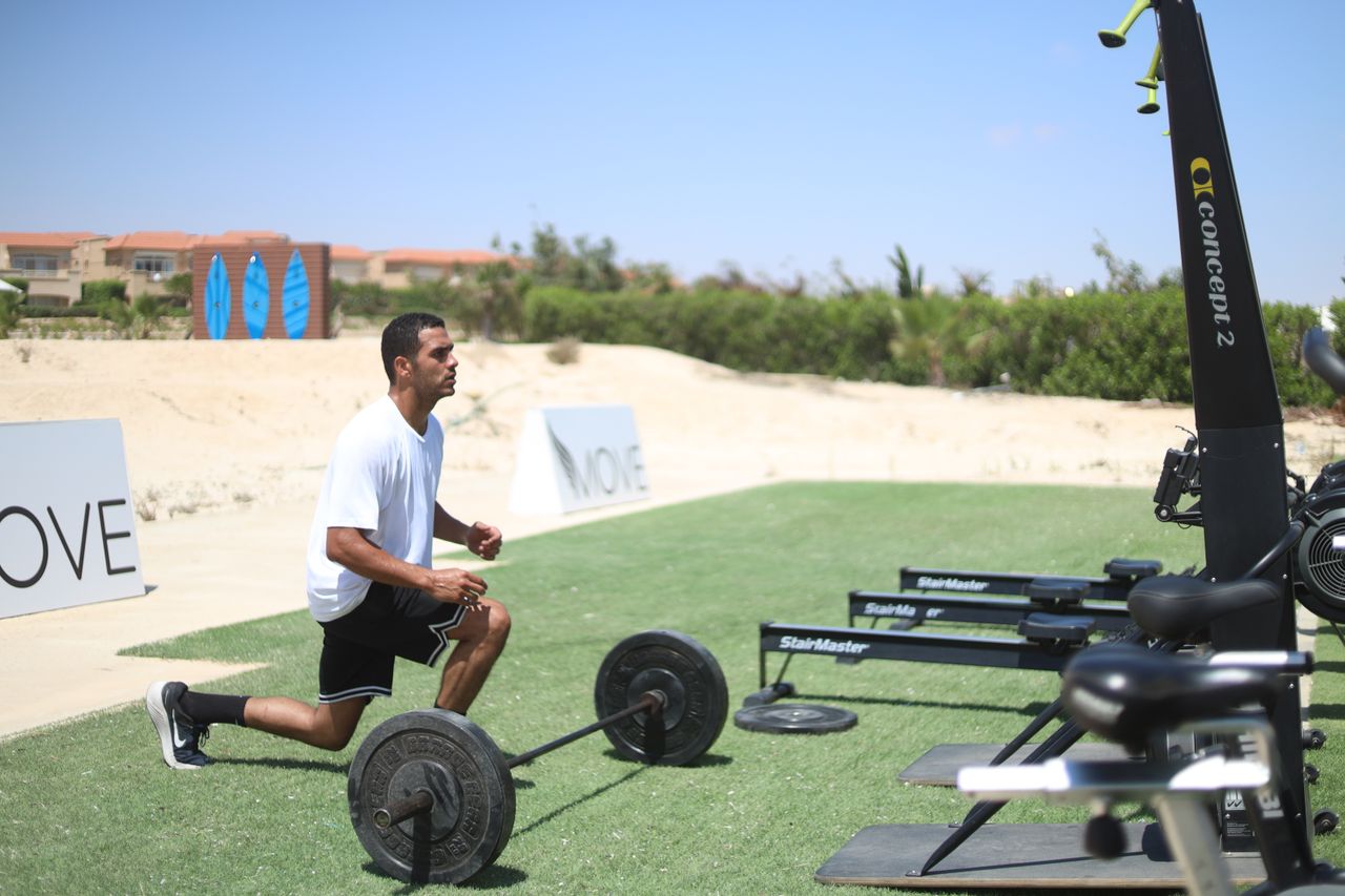 services-03 Man working out with barbell outdoors, focusing on dynamic fitness and strength.