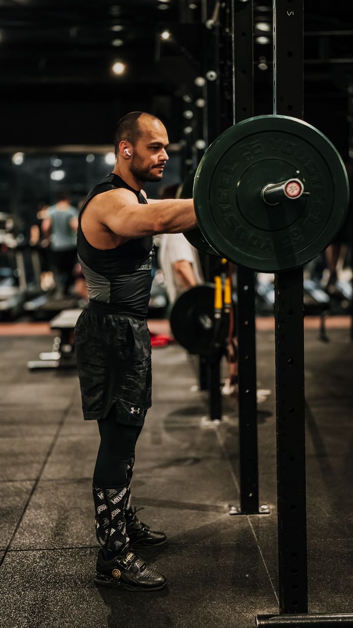gallery-1 Male weightlifter exercises in a gym lifting heavyweights, showcasing strength and endurance.